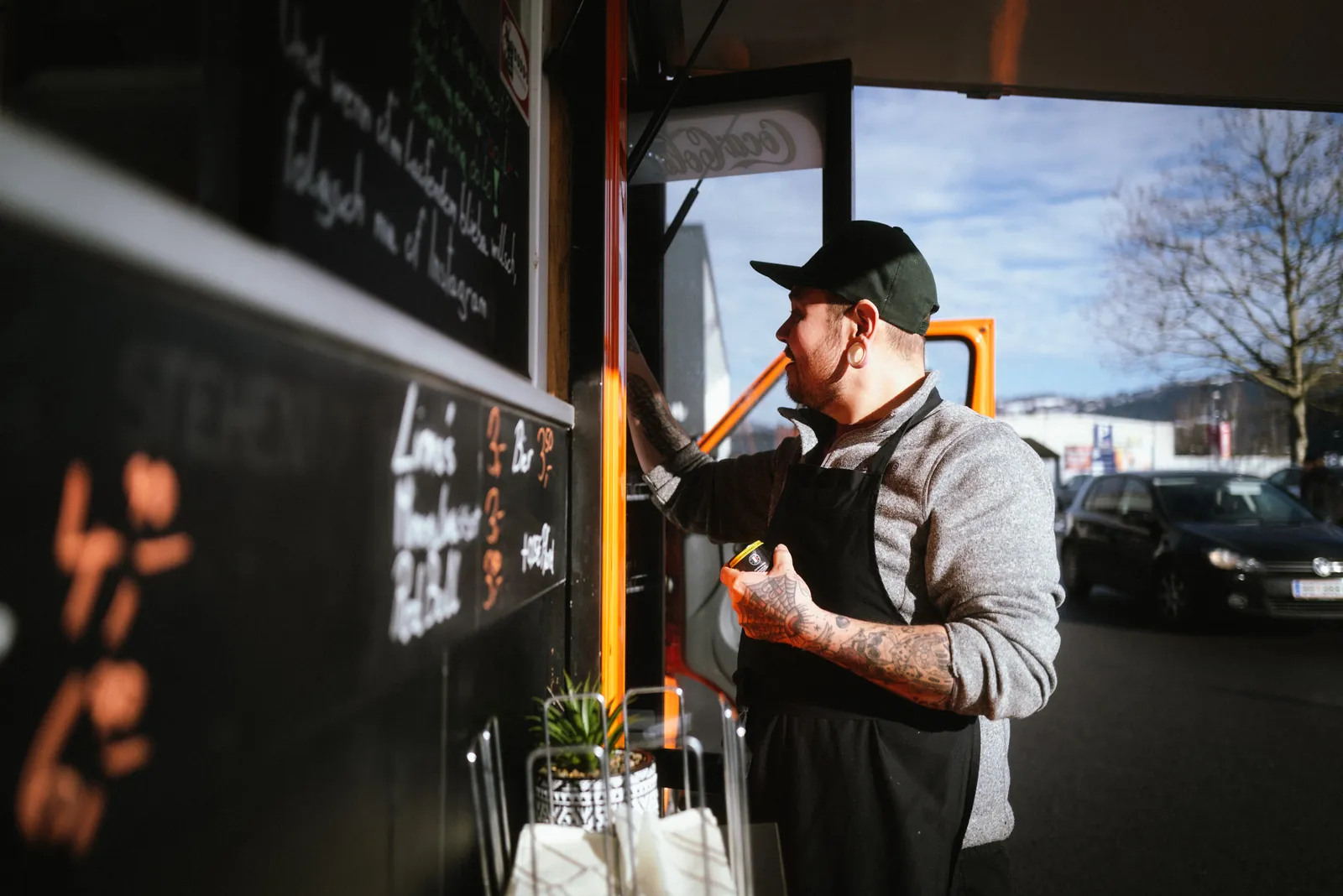 Manuel schreibt das Angebot auf die Kreidetafel am Truck