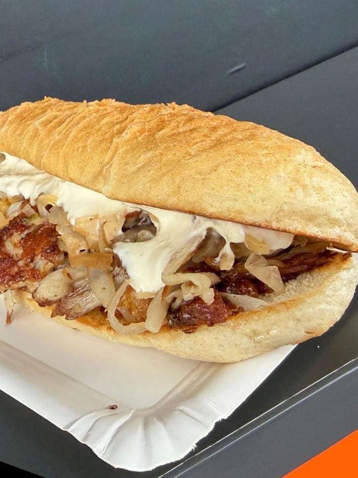 Bratensandwich mit zartem Braten, Kraut und Sauce im Weckerl